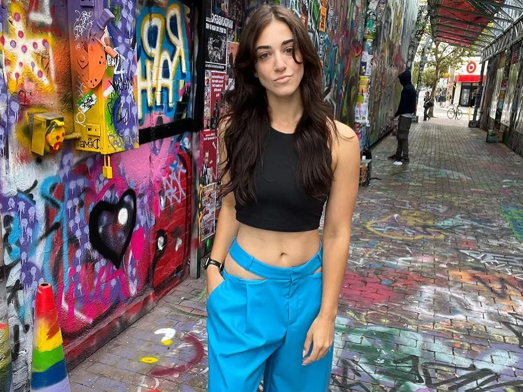 Oriana Schneps shows off her fit figure in a dark top and light blue pants.