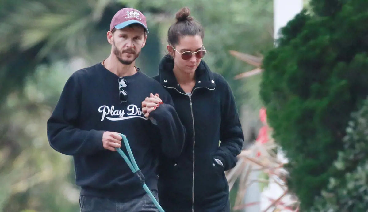 Ryan and Ashley holding hands as they walk their dog on Monday in 2018