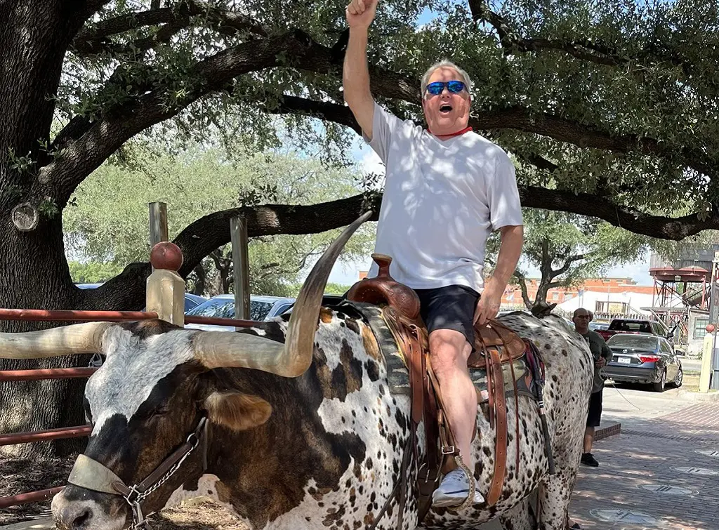 Greg Luzinski sharing a ride in a bull cheering up for Phillies in Texas on the steer