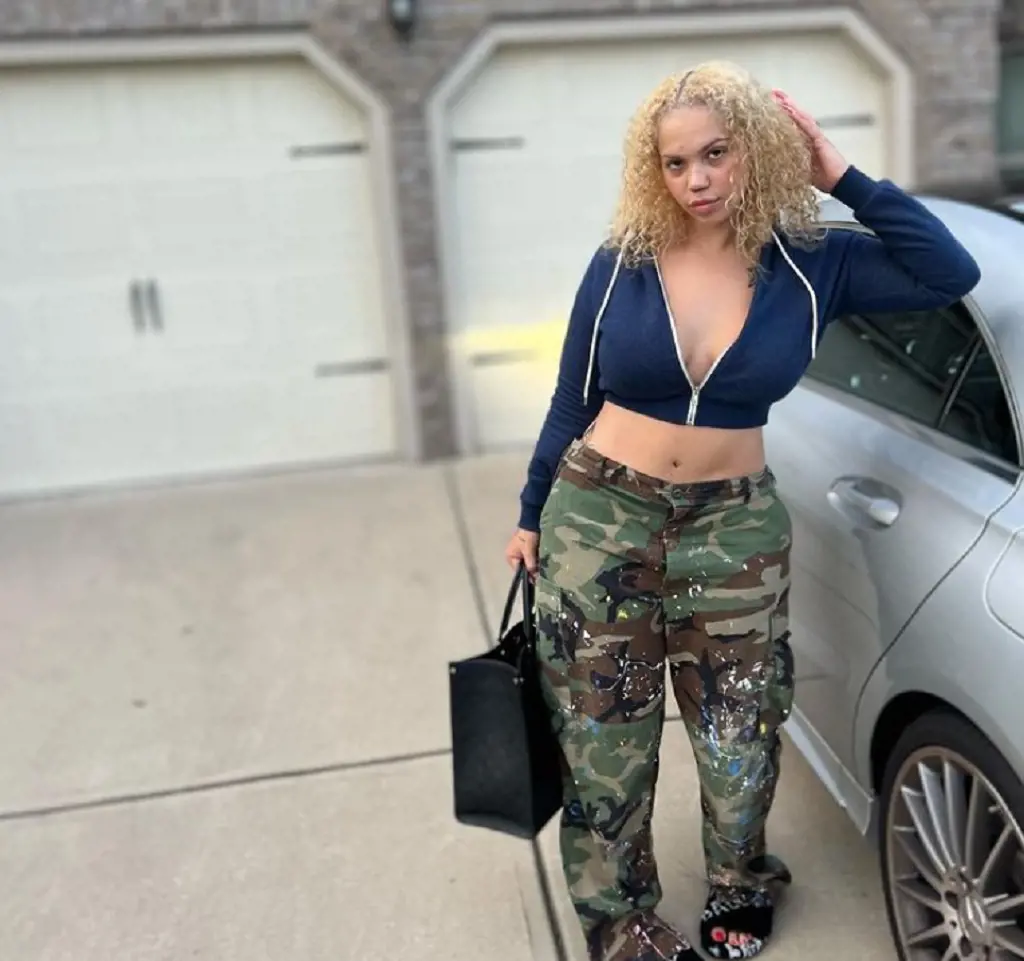 Renni posing in front of her car