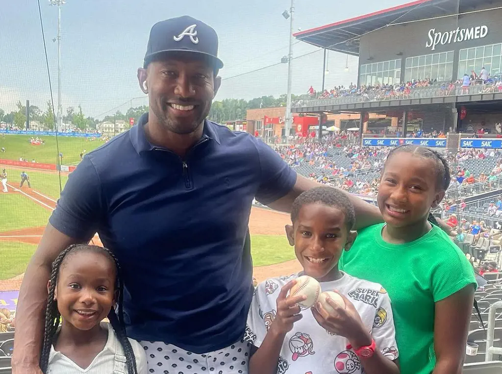 Martell Holt watched a baseball match with his two daughters and one son