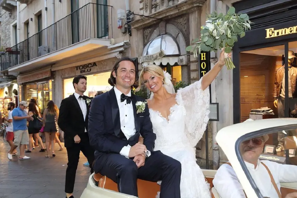Courtney Hansen and Jay Hartington at their wedding, as they ride in the street of scenic Italy