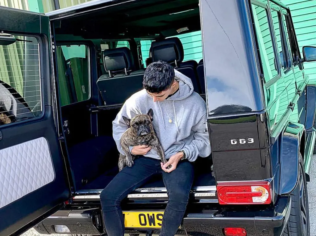 Omid Scobie in Oxford, Oxfordshire with his dog in the luxurious car