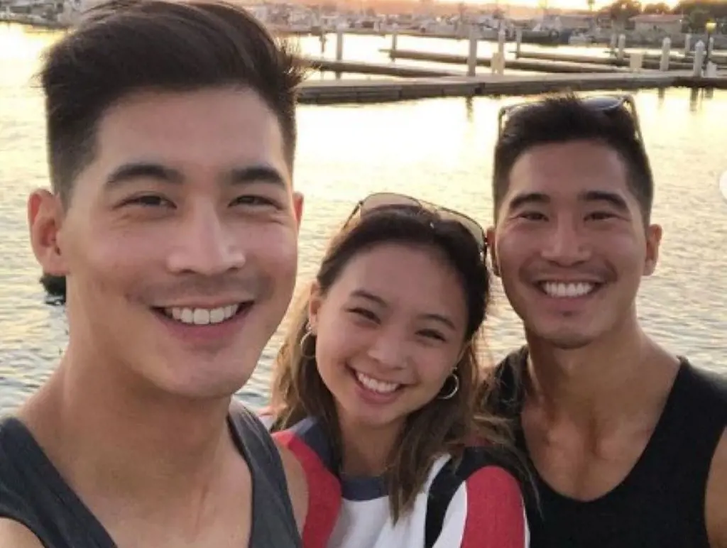 Eddie Liu outdoors in a port with his older brother and sister