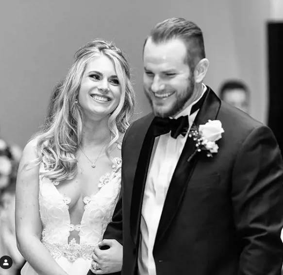Max Muncy with his wife in their wedding.