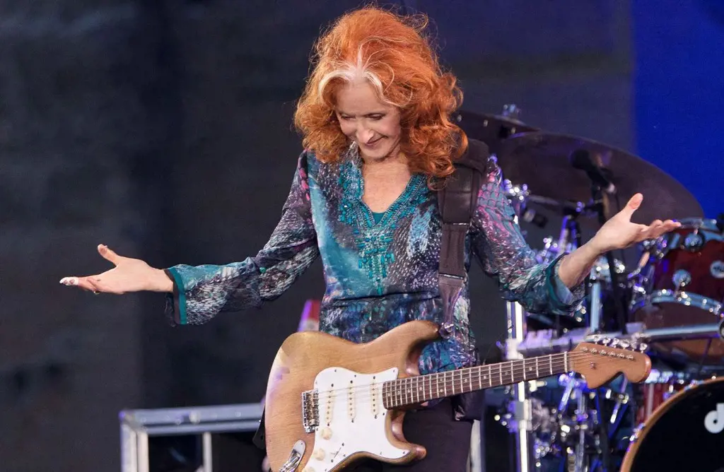 Bonnie Raitt playing guitar in one of her shows