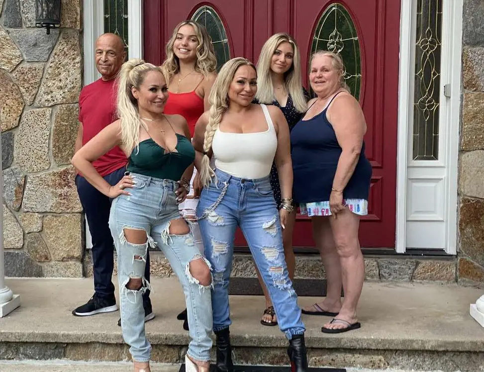 Nancy Silva, Darcey (right center), Aspen (second from right), Stacey (left center),Aniko (second from left), Mike posing in front of their Mansion